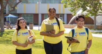 Three Students on LAHC t-shirt uniform and walking on the Lawn